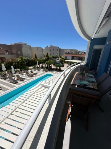 a balcony with a pool and a table and chairs at Evdokia Suites in Gouves