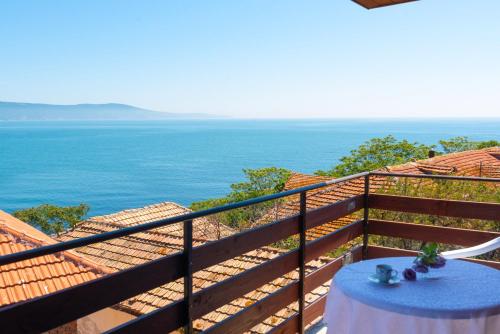 a table on a balcony with a view of the ocean at Royal Blue Apartments with Sea View in Old Nessebar in Nesebar