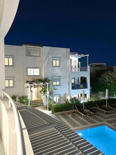 a building with a swimming pool in front of a building at Evdokia Suites in Gouves