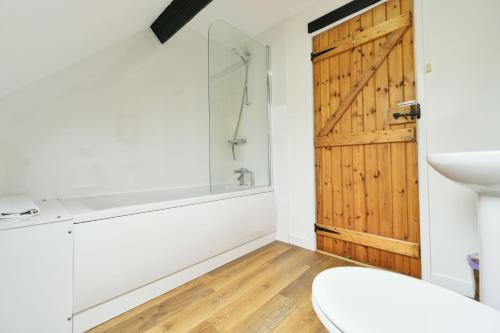bagno con doccia e porta in legno di Stable Cottage Wheddon Cross a Minehead