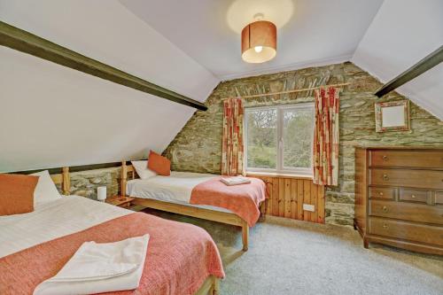 una camera da letto con due letti e una finestra di Stable Cottage Wheddon Cross a Minehead