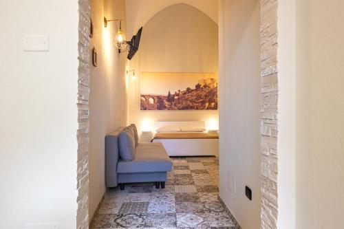 a hallway with a blue chair and a bed at Sg Apartment Standard Plus in Massafra
