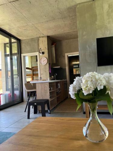 a vase filled with white flowers sitting on a table at Nina's house & Yard 200m from beach Kaprovani in Ureki
