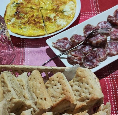 a table with two plates of food with bread and meatballs at Bonaventura b&b and Bonaventura food in Tollo