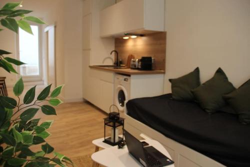 Cette chambre comprend un lit et un ordinateur portable sur une table. dans l'établissement Le Cactus - Appartement avec terrasse, à Marseille