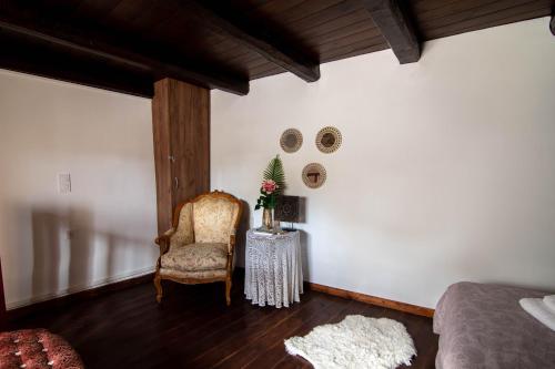 a bedroom with a bed and a chair and a table at Hercules Traditional Houses in Gálipe