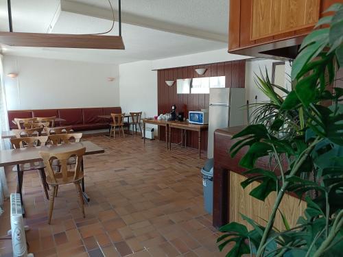 a dining room with tables and chairs and a kitchen at Chambre Triple avec Salle de Bains Privative 2 in Vallouise