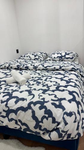 un lit avec une couette bleue et blanche avec un animal en peluche dessus dans l'établissement Studio Cosy, à Paris