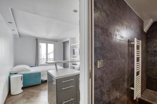 - une chambre avec un lit et un lavabo dans l'établissement Studio Charmant à Deux Pas de l'Élysée Luxe et Confort au Cœur de Paris, à Paris
