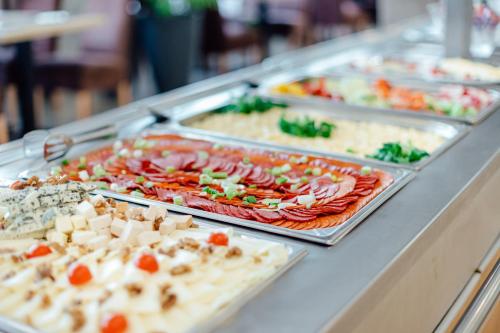 a buffet with many trays of food on a table at GALANDA APARTMENTS in Turčianske Teplice