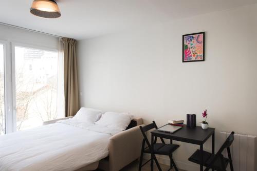 une chambre avec un lit, un bureau et une fenêtre dans l'établissement HomyParis, à Paris