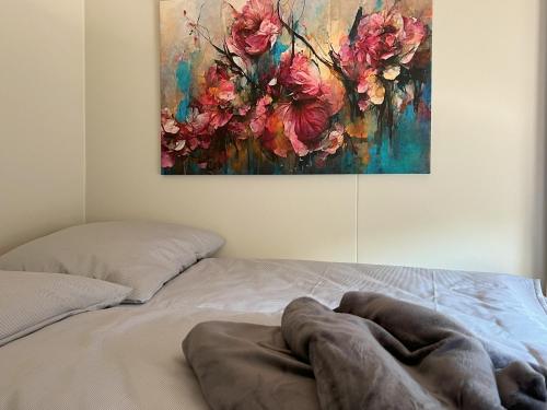 a bedroom with a bed with a painting on the wall at Tiny Haus Park Fritzlar in Fritzlar