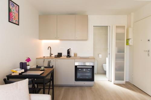 - une petite cuisine avec une table et un comptoir dans l'établissement HomyParis, à Paris