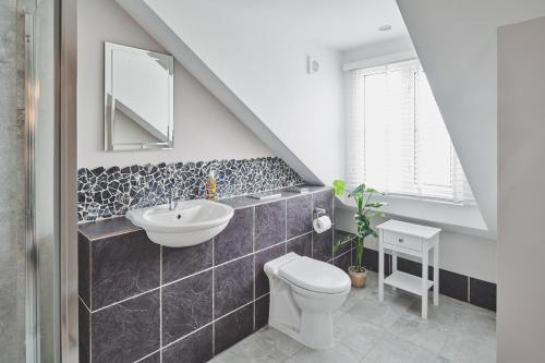 a bathroom with a sink toilet and a mirror at The Lansdowne Boutique Rooms with Breakfast - Adults Only in Bourton on the Water