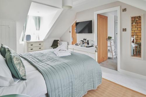 a white bedroom with a bed and a sink at The Lansdowne Boutique Rooms with Breakfast - Adults Only in Bourton on the Water