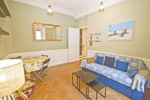 un salon avec un canapé bleu et une table dans l'établissement Villa Rivoli City Center Nice, à Nice