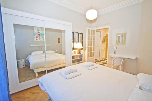 - une chambre blanche avec 2 lits et un miroir dans l'établissement Villa Rivoli City Center Nice, à Nice