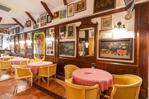 a restaurant with tables and chairs and pictures on the walls at Casa del Sole Boutique Hotel Timisoara in Timişoara