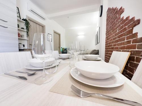 a dining room with a table with wine glasses at Vigentino Suites in Milan