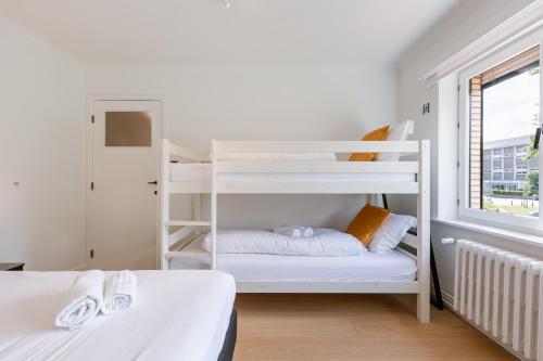 une chambre avec deux lits superposés et une fenêtre dans l'établissement Maison Elice, à La Panne