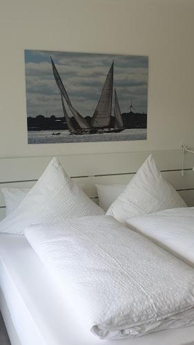 a white bed with a picture of two sail boats at FeWo Machedanz strandnah Timmendorf Strand in Timmendorfer Strand
