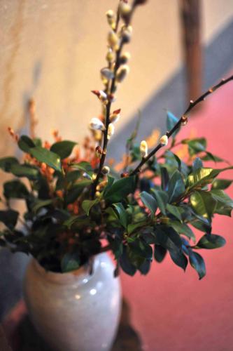 a white vase with a plant in it at Atami Onsen Yamaki Ryokan in Atami