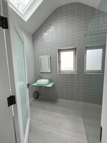 a bathroom with a sink and a mirror at Kathleen's Carrowkeel Cottage in Sligo