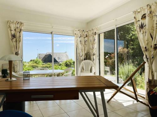 un salon avec une table et une grande fenêtre dans l'établissement Maison coquette proche plage à La Forêt-Fouesnant - FR-1-481-159, à La Forêt-Fouesnant