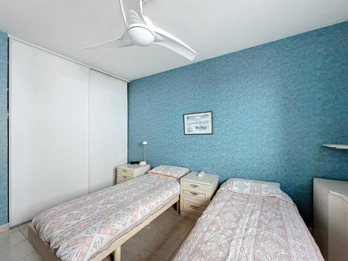 deux lits dans une chambre aux murs bleus dans l'établissement Appartement T3 avec climatisation et parking à La Ciotat (4 pers) - FR-1-770-17, à La Ciotat