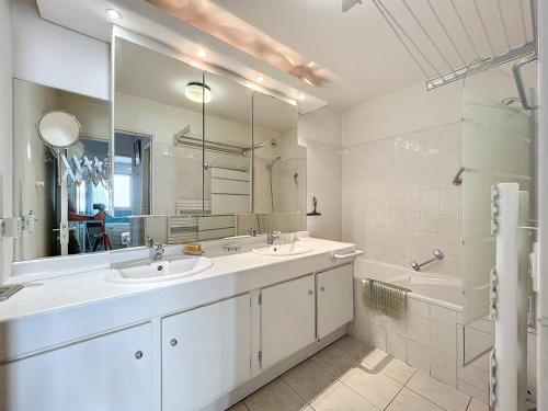 une salle de bain avec deux lavabos et un grand miroir dans l'établissement Appartement T3 avec climatisation et parking à La Ciotat (4 pers) - FR-1-770-17, à La Ciotat