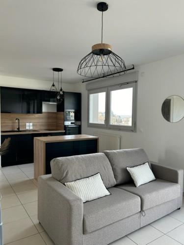 un salon avec un canapé et une cuisine dans l'établissement M43 Marquer Joli T3 proche du centre ville d'Annemasse, à Annemasse
