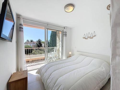 une chambre blanche avec un lit et une grande fenêtre dans l'établissement Appartement Moderne et Lumineux à 2 Pas de la Plage, Parking Inclus - FR-1-770-27, à La Ciotat