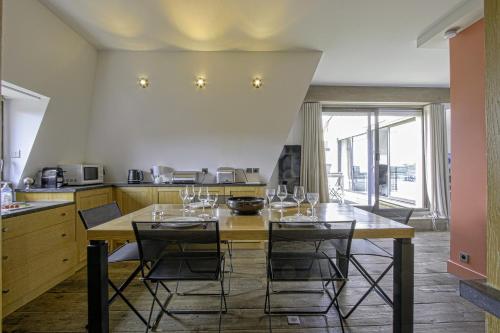 une cuisine avec une table avec des verres à vin dessus dans l'établissement Le Roof Top-Apt T4-Proche Mer et Centre Ville, à Deauville