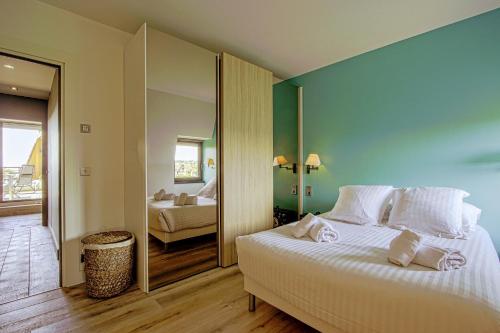 une chambre avec un grand lit blanc avec un miroir dans l'établissement Le Roof Top-Apt T4-Proche Mer et Centre Ville, à Deauville