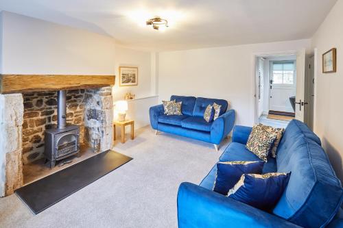 a living room with a blue couch and a fireplace at Host & Stay - Kenmore in Corbridge