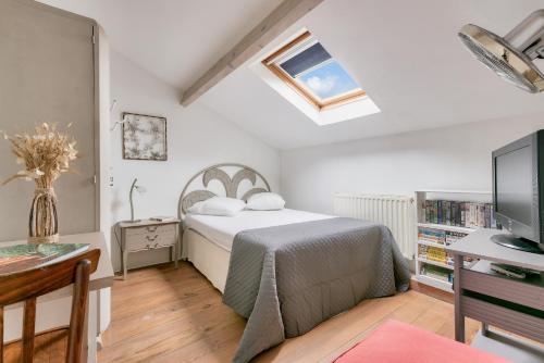 une chambre avec un lit, un bureau et une télévision dans l'établissement À 400m de la plage, maison pour 8 avec piscine, à Andernos-les-Bains