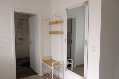 a mirror in a bathroom with a chair in front of it at Ferienhaus SeenSuchtLausitz in Großräschen
