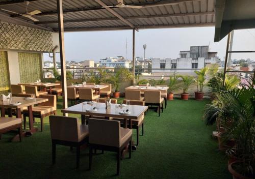 a restaurant with tables and chairs on a patio at Hotel Galaxy in Indore