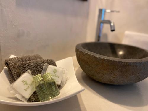 a bowl and towels on a plate next to a sink at Superbe T2 coté gare Parking Clim Wifi Terrasse ! in Sète
