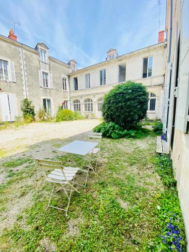 deux chaises et une table devant un bâtiment dans l'établissement Le Gîte Du Parc avec parking vieux port et plage au calme, à La Rochelle