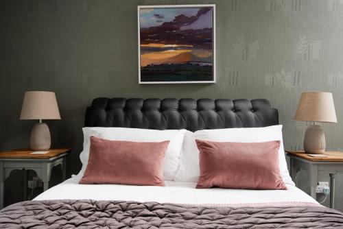 una camera da letto con un letto grande con cuscini rossi di The Old Post Office, Cosy Cottage in Northumberland, Near Coast, Dog Friendly a Chatton