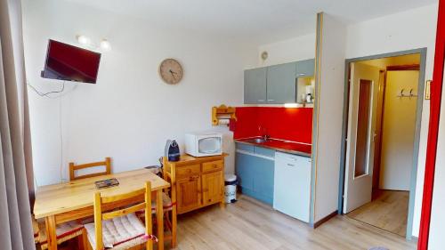 une petite cuisine avec une table et un micro-ondes dans l'établissement Studio 4 pers Le Sauze pied des pistes de ski, à Enchastrayes
