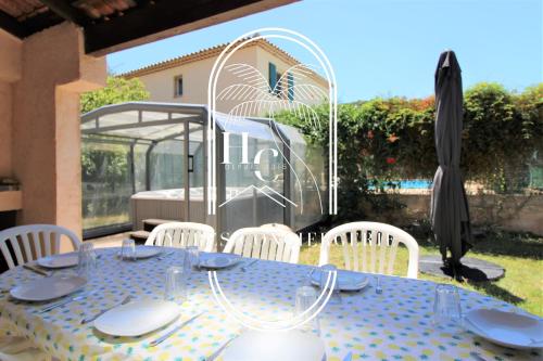 une table bleue avec des assiettes blanches sur une terrasse dans l'établissement Villa 4 Chambres Jardin Jacuzzi Hyères PK CLIM By HC, à Hyères