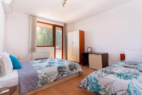 a bedroom with two beds and a window at Royal Blue Apartments with Sea View in Old Nessebar in Nesebar