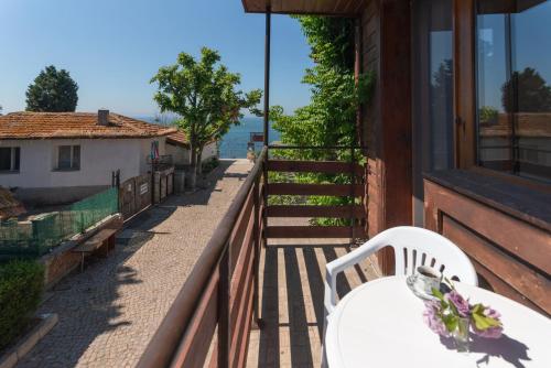 a balcony with a table and chairs on a house at Royal Blue Apartments with Sea View in Old Nessebar in Nesebar