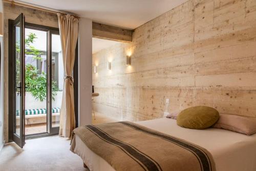 - une chambre avec un lit et un mur en bois dans l'établissement maison granite Malmousque, à Marseille