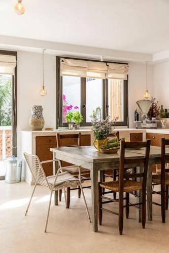 une cuisine avec une table et des chaises en bois dans l'établissement maison granite Malmousque, à Marseille