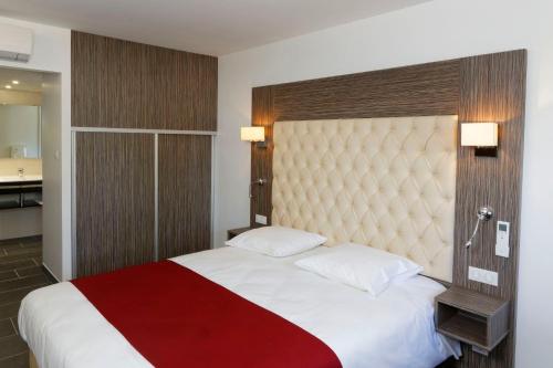 a bedroom with a large bed with a red blanket at Hotel du Lac Foix in Foix