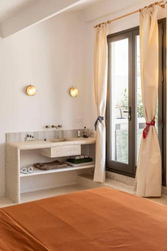 une chambre blanche avec un lit et une fenêtre dans l'établissement maison granite Malmousque, à Marseille