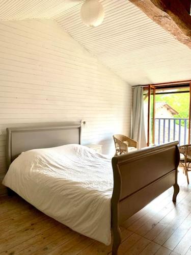 une chambre avec un lit dans une pièce avec une fenêtre dans l'établissement Evasion enchantée, maison au cœur de la forêt, à Léogeats